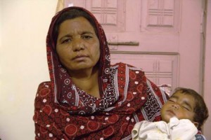 Parveen Bibi, sister of the murdered husband, holds the dead couple's baby