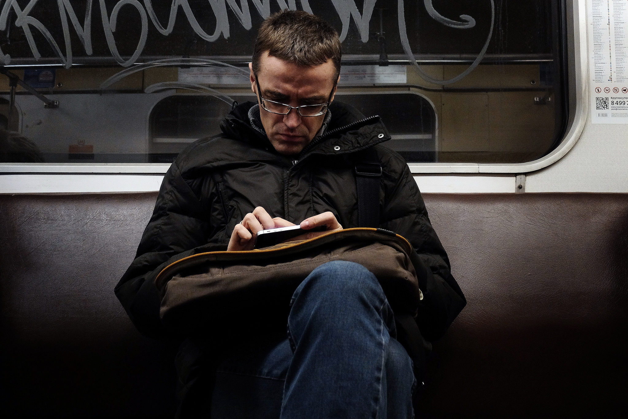 A man reads using his smartphone on the subway
