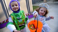 Two children show off their Halloween candy