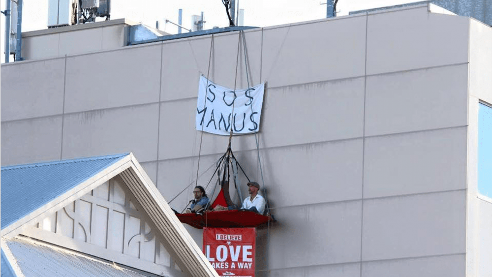 Jarrod McKenna and Delroy Bergsma are suspended four storeys up, protesting what is happening on Manus Island