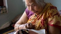 A leprosy victim in Nepal reads the Bible.